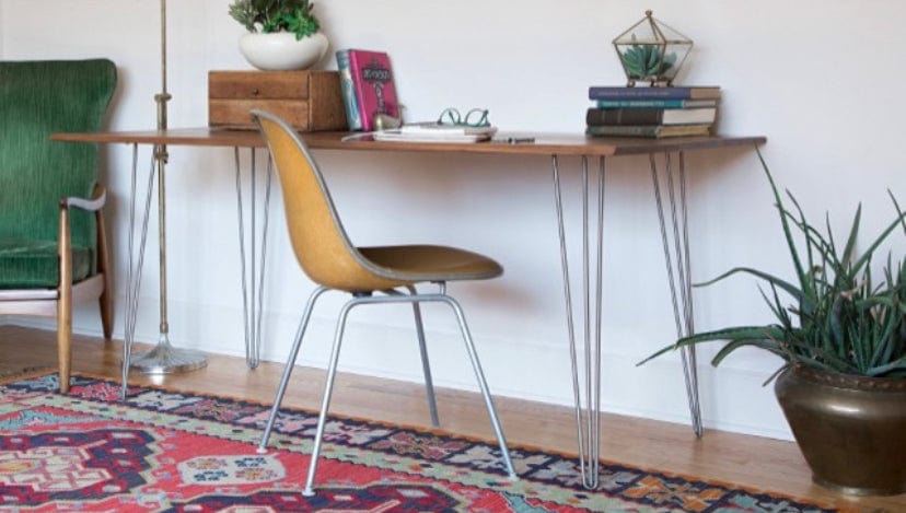 Four Stainless steel three rod hairpin legs installed on a wood desk with chairs.